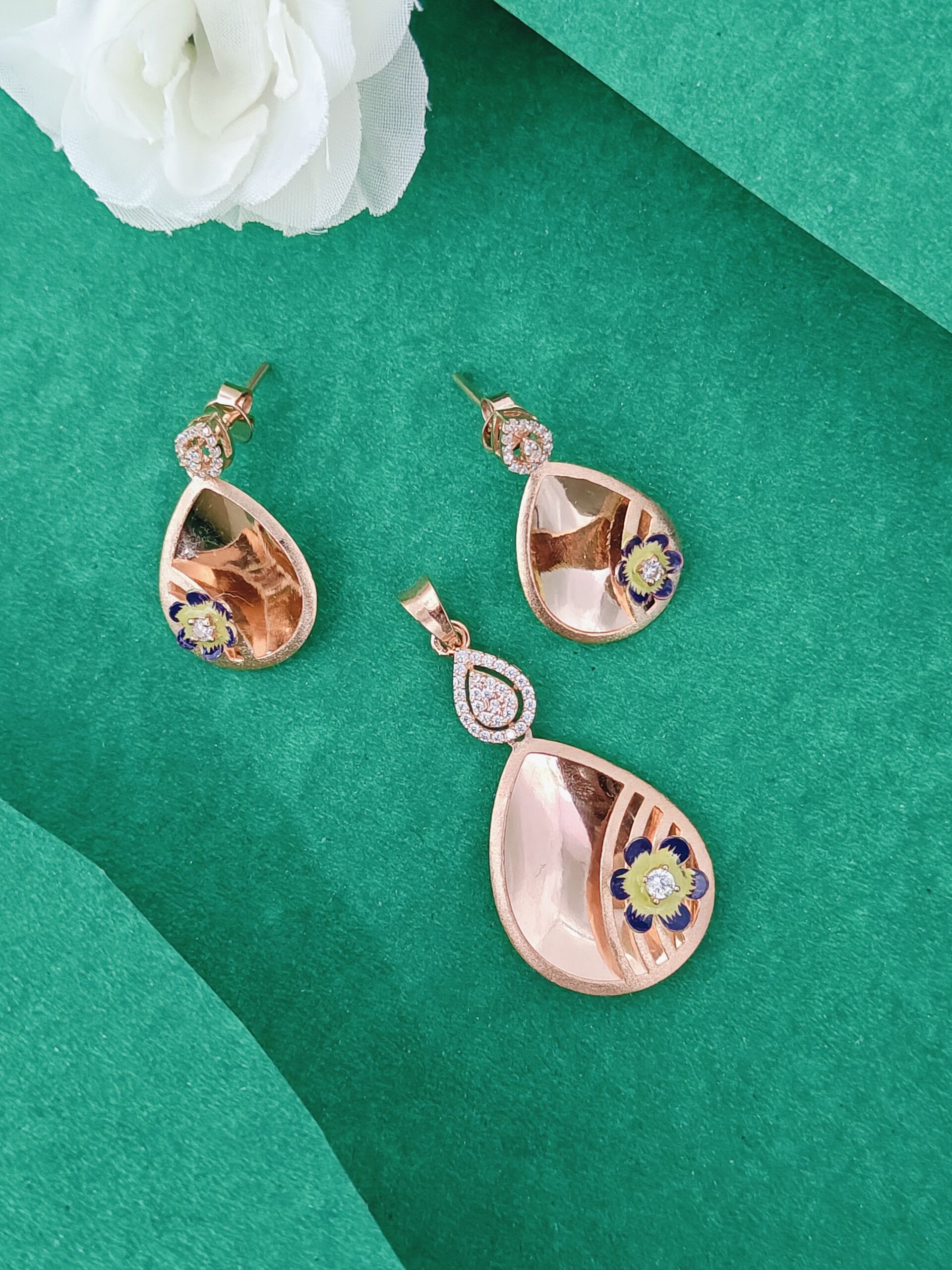 Teardrop-shaped earrings with floral designs on a green background